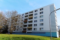 Wohnhaus 6 Etagen, Flachdach. Weiße Plattenfassade, Balkonbrüstungen farbig. Davr Wiese.