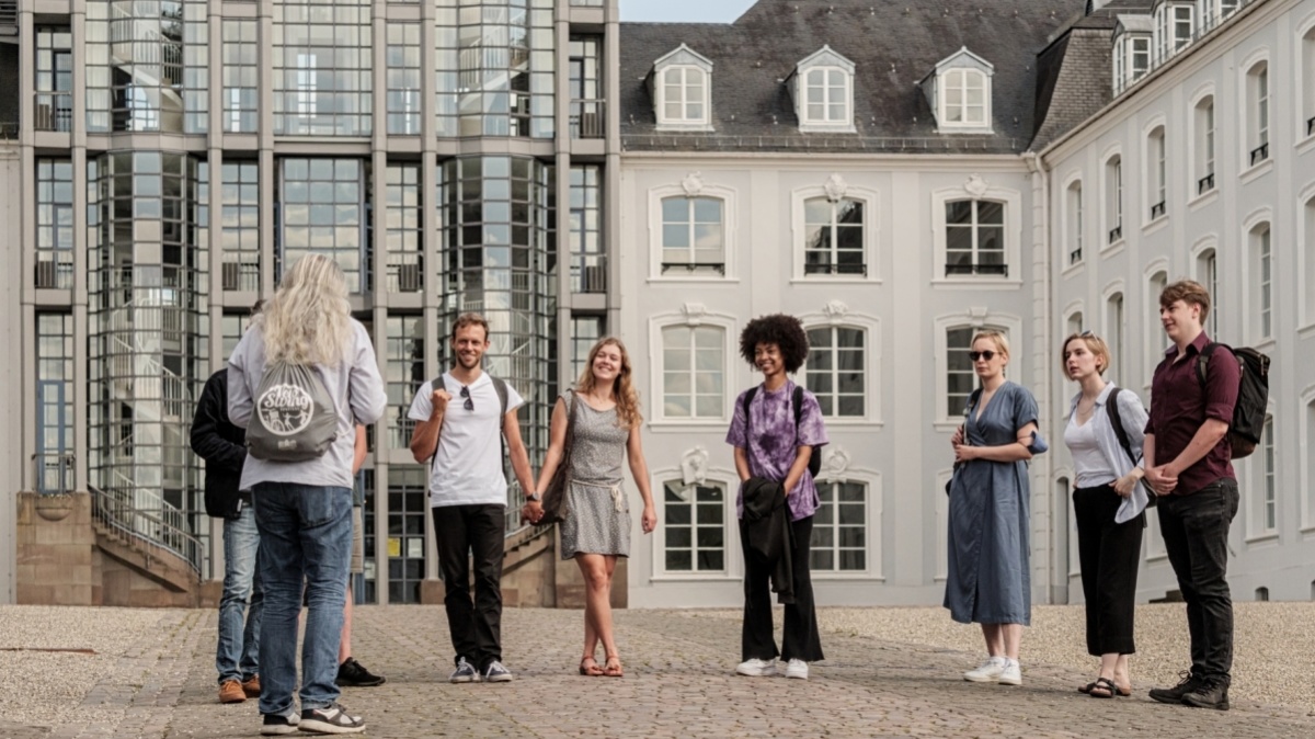 Gruppe von Touristen während einer Stadtführung vor dem Saarbrücker Schloss