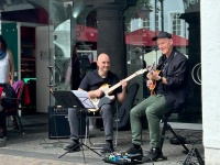 Zwei Männer mit Gitarre und Notenständer