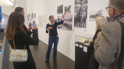 Besuch im Historischen Museum Saar mit der Cottbuser Delegation Eine Frau beschreibt ein Foto, mehrere Besucher stehen davor