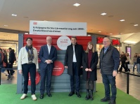 Sechs Personen stehen vor einer AUsstellungswand