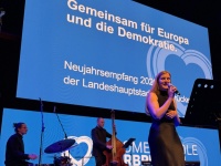 Neujahrsempfang der Landeshauptstadt 2026 Eine Band auf einer Bühne, dahinter eine Leinwand mit blauem Motiv
