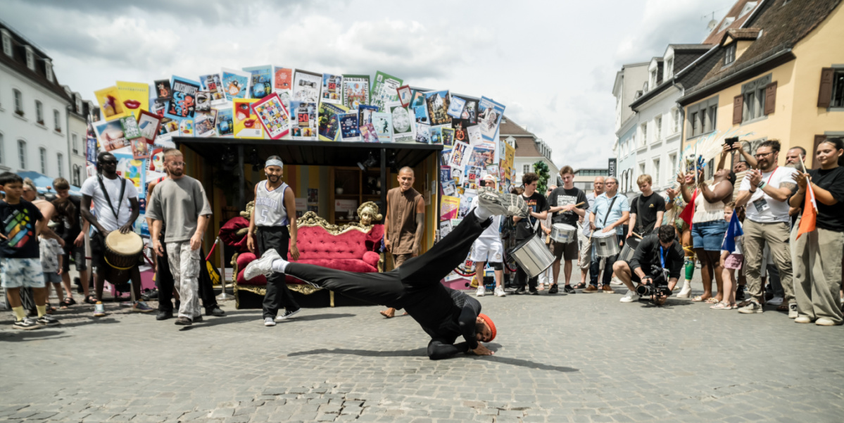 Breakdance-Move auf Kopfsteinpflaster, Publikum staunt