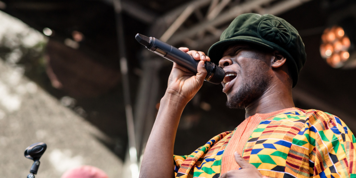 Sänger im Kente-Gewand performt leidenschaftlich am Mikro