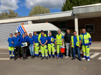Mitarbeitende der Stadtwerke Saarbrücken Netz AG in Arbeitskleidung stehen gemeinsam vor einem Fahrzeug.